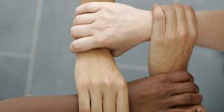 Vier Hände formen ein Viereck als Symbolbild für gegenseitige Hilfe