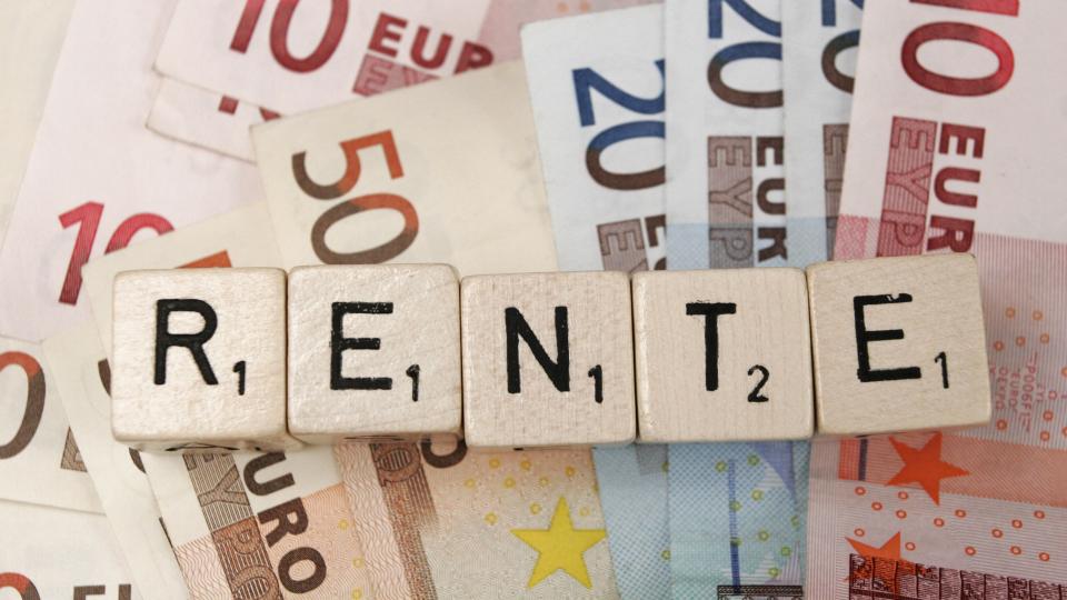 Fotos zeigt Spieltsteine die das Wort Rente bilden vor Euroscheinen
