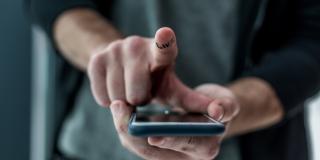 Hand mit Zeigefinger auf Smartphone-Display